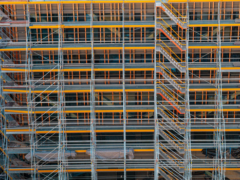 Aerial view of construction scaffolding covering the facade of the Helmholtz Zentrum Berlin building with yellow beams and metal stairs in Berlin Berlin Germany.