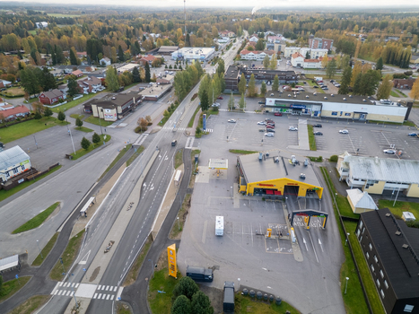 Muhos Finland 22 September 2026 Aerial view of the town center featuring a main road a gas station commercial buildings and surrounding autumn forests.