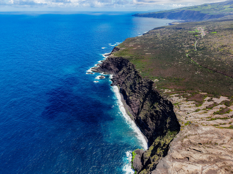 Aerial view of the rugged coastline meets the deep blue sea a stark contrast of textures and tones Capelo A&ccedil;ores Portugal.