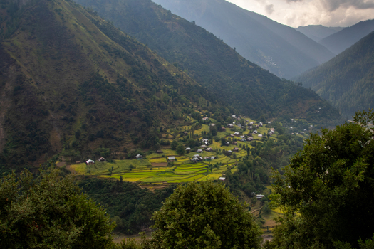 View of Neelum Valley with terraced fields small village houses and lush green mountains under a cloudy sky in Neelum Kashmir Pakistan. View of Neelum Valley with terraced fields small village houses and lush green mountains under a cloudy sky in Neelum Kashmir Pakistan.