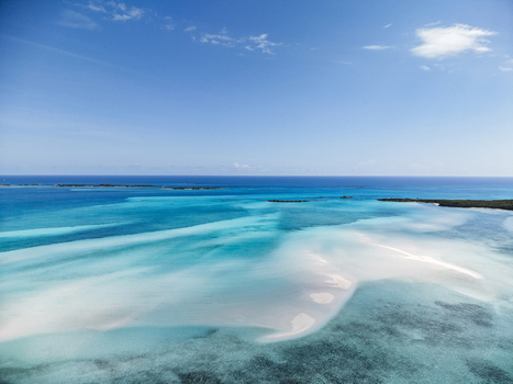 Aerial view of the turquoise waters and white sandbars of Man O War Cay Sandbar under a clear blue sky in Rolletown Exuma The Bahamas. Aerial view of the turquoise waters and white sandbars of Man O War Cay Sandbar under a clear blue sky in Rolletown Exuma The Bahamas.