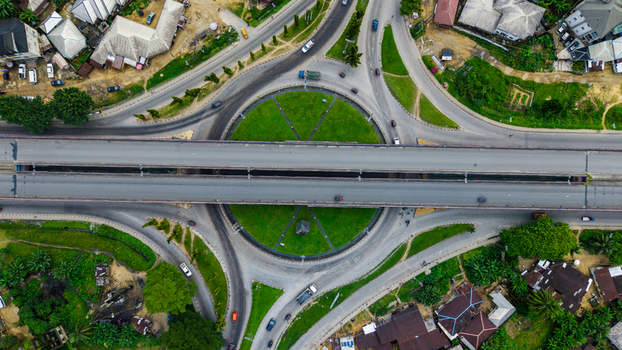 Aerial view of a large roundabout with a central green space and an elevated highway bridge crossing over it surrounded by urban residential areas in Uyo Akwa Ibom Nigeria. Aerial view of a large roundabout with a central green space and an elevated highway bridge crossing over it surrounded by urban residential areas in Uyo Akwa Ibom Nigeria.