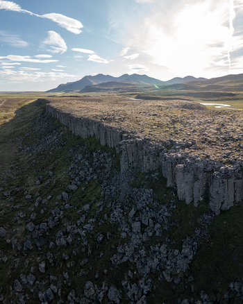 Aerial view of the basalt columns of Gerduberg Cliffs with rugged volcanic terrain mossy rocks and distant mountains in Raudhamelur Eyja og Miklaholtshr Iceland. Aerial view of the basalt columns of Gerduberg Cliffs with rugged volcanic terrain mossy rocks and distant mountains in Raudhamelur Eyja og Miklaholtshr Iceland.