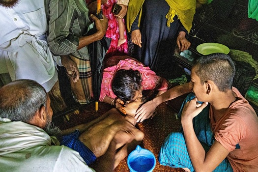 Banshkhali Upazila Bangladesh 10 July 2026 View of a woman comforting a young boy lying on the floor surrounded by family members in a home setting. Banshkhali Upazila Bangladesh 10 July 2026 View of a woman comforting a young boy lying on the floor surrounded by family members in a home setting.