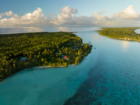 Aerial view of a lush green island fringed by turquoise waters meeting the deep blue sea Ouvéa Loyalty Islands Province New Caledonia. Aerial view of a lush green island fringed by turquoise waters meeting the deep blue sea Ouvéa Loyalty Islands Province New Caledonia.