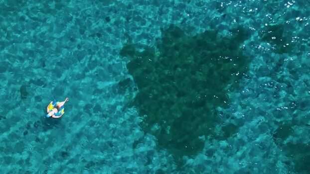 Aerial view of a person floating in turquoise water Honduras. Aerial view of a person floating in turquoise water Honduras.