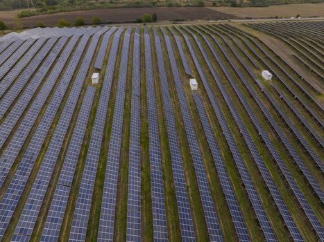 Aerial view of rows of solar panels in a large solar farm set in a rural landscape in Bulgaria. Aerial view of rows of solar panels in a large solar farm set in a rural landscape in Bulgaria.