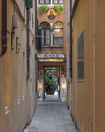 Venice Italy 21 September 2026 View of the entrance to Hotel Flora a charming boutique hotel tucked into a narrow stone paved alleyway with historic architecture and lion statues. Venice Italy 21 September 2026 View of the entrance to Hotel Flora a charming boutique hotel tucked into a narrow stone paved alleyway with historic architecture and lion statues.