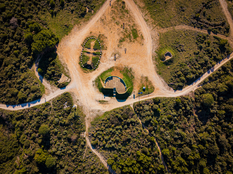 Aerial view of earthy pathways converge around ancient stone structures amidst verdant foliage casting shadows under the Croatian sun Pula Istria County Croatia.