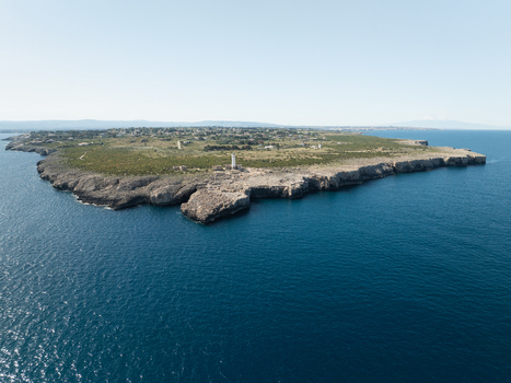 Aerial view of the Plemmirio peninsula with its lighthouse and rugged rocky cliffs overlooking the deep blue Mediterranean Sea Plemmirio Sicily Italy. Aerial view of the Plemmirio peninsula with its lighthouse and rugged rocky cliffs overlooking the deep blue Mediterranean Sea Plemmirio Sicily Italy.