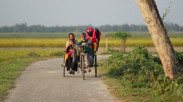 View of a family riding a cycle rickshaw on a rural road Bangladesh. View of a family riding a cycle rickshaw on a rural road Bangladesh.