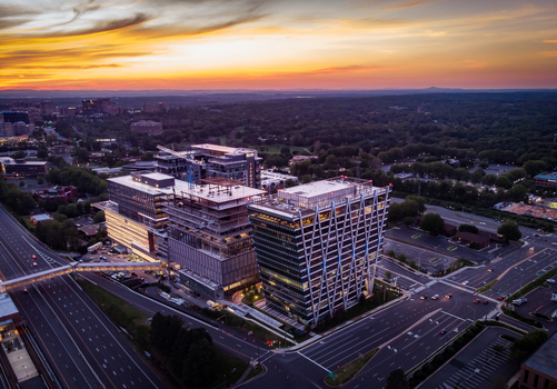 Reston United States 27 May 2020 Aerial view of modern office buildings and construction sites at sunset with a highway and surrounding greenery. Reston United States 27 May 2020 Aerial view of modern office buildings and construction sites at sunset with a highway and surrounding greenery.