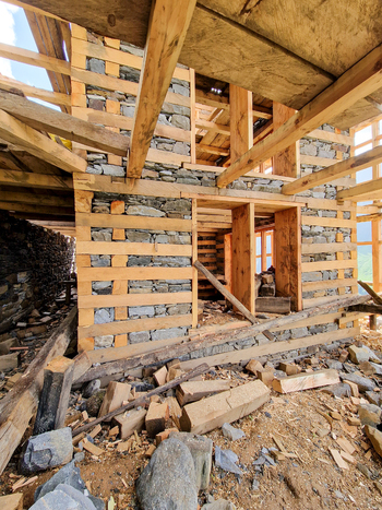 View of a traditional stone and timber house under construction in the historic village of Malana Himachal Pradesh India.