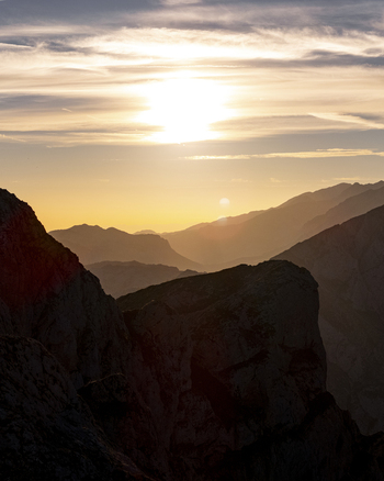 Aerial view of the sun s golden glow kissing the rugged peaks and casting long shadows across the serene valleys of Picos de Europa Picos de Europa Asturias Spain.