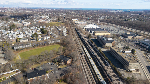 Aerial view of the train tracks cutting through the urban landscape near commercial buildings and residential areas Braintree Massachusetts United States.