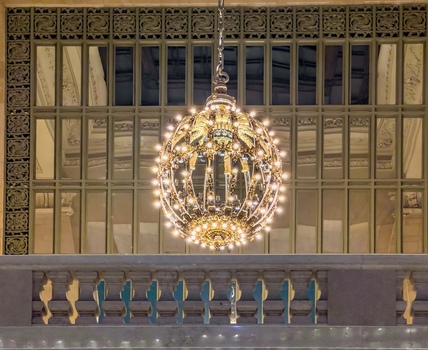 View of the ornate golden chandelier hanging in the main concourse of Grand Central Terminal with decorative architectural details New York New York United States. View of the ornate golden chandelier hanging in the main concourse of Grand Central Terminal with decorative architectural details New York New York United States.
