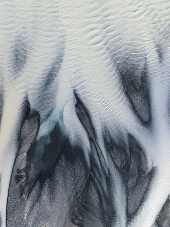 Aerial view of glacial rivers carve paths through the stark textured landscape contrasting icy whites and dark silty earth Lake Tekapo Canterbury Region New Zealand. Aerial view of glacial rivers carve paths through the stark textured landscape contrasting icy whites and dark silty earth Lake Tekapo Canterbury Region New Zealand.