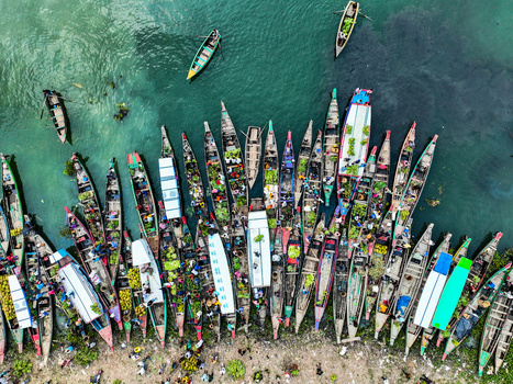 Rangamati Hill District Bangladesh 18 May 2024 Aerial view of Kaptai Lake featuring numerous wooden boats laden with fresh produce and goods moored along the shoreline.