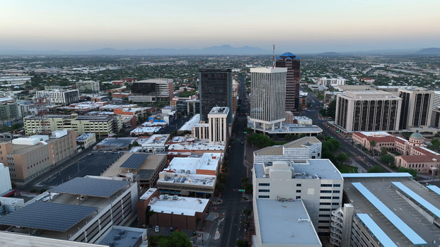 Aerial view of the downtown Tucson skyline at sunrise featuring office buildings parking structures with solar panels and urban streets in Tucson Arizona United States. Aerial view of the downtown Tucson skyline at sunrise featuring office buildings parking structures with solar panels and urban streets in Tucson Arizona United States.