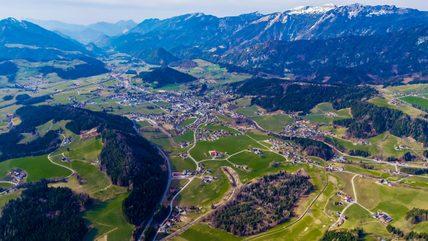 Aerial view of the valley s tapestry where emerald meadows meet the quaint village nestled amidst the majestic snow capped peaks Windischgarsten Upper Austria Austria. Aerial view of the valley s tapestry where emerald meadows meet the quaint village nestled amidst the majestic snow capped peaks Windischgarsten Upper Austria Austria.