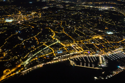 Aerial view of the illuminated marina and city lights of Antibes at night featuring the coastline and urban grid in Antibes Provence Alpes Cote d Azur France. Aerial view of the illuminated marina and city lights of Antibes at night featuring the coastline and urban grid in Antibes Provence Alpes Cote d Azur France.