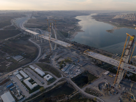 Aerial view of the construction of a large cable stayed bridge spanning a reservoir with cranes support structures and surrounding landscape in Istanbul Istanbul Turkiye.