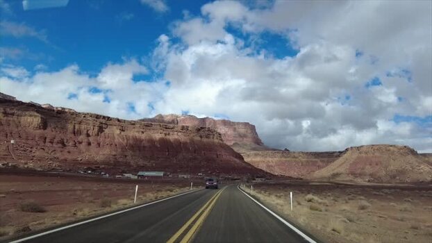 View of a desert road and red rock formations United States. View of a desert road and red rock formations United States.