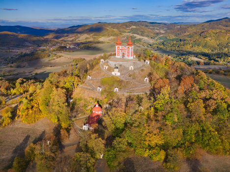 Aerial view of the Stiavnica Calvary a historic pilgrimage site with a hilltop church and winding paths surrounded by autumn forests in Banska Stiavnica Banskobystricky kraj Slovakia. Aerial view of the Stiavnica Calvary a historic pilgrimage site with a hilltop church and winding paths surrounded by autumn forests in Banska Stiavnica Banskobystricky kraj Slovakia.