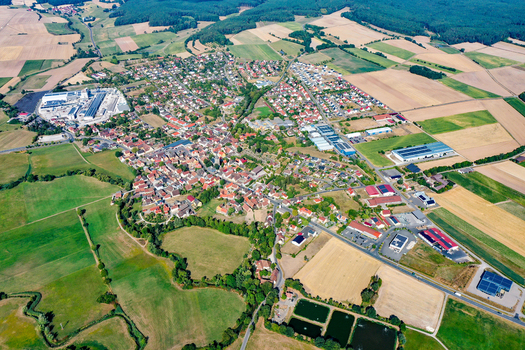 Aerial view of the town of Uehlfeld with red roofed houses surrounded by agricultural fields and green forests in Uehlfeld Bavaria Germany.