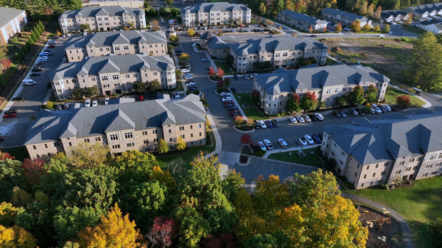 Aerial view of a modern apartment complex with multiple buildings parking lots and autumn foliage in Lynchburg Virginia United States.