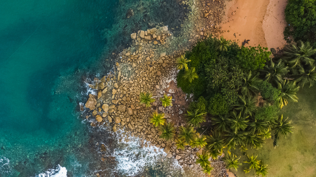 Axim Western Region Ghana 09 February 2023 Aerial view of Lou Moon Resort Eco Luxury featuring a rocky coastline lush palm trees and turquoise ocean waters. Axim Western Region Ghana 09 February 2023 Aerial view of Lou Moon Resort Eco Luxury featuring a rocky coastline lush palm trees and turquoise ocean waters.