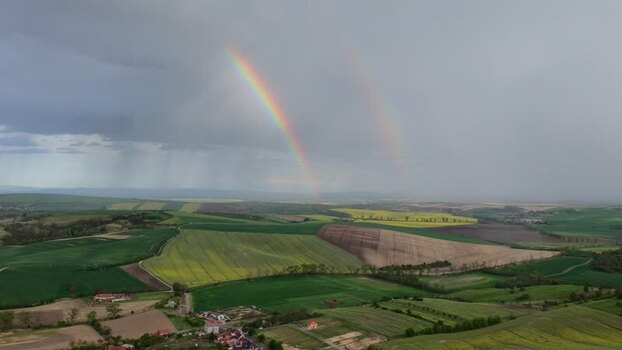 Aerial view of a double rainbow over rolling fields Czechia.