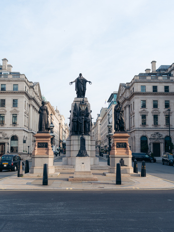 London United Kingdom 20 June 2025 View of the Crimean War Memorial stands tall its bronze figures a solemn contrast to the pale stone buildings lining the wide sun drenched street. London United Kingdom 20 June 2025 View of the Crimean War Memorial stands tall its bronze figures a solemn contrast to the pale stone buildings lining the wide sun drenched street.