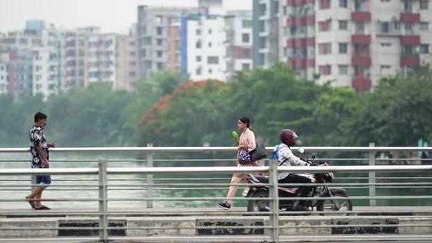 View of people and a motorcyclist on a bridge in Dhaka Bangladesh.