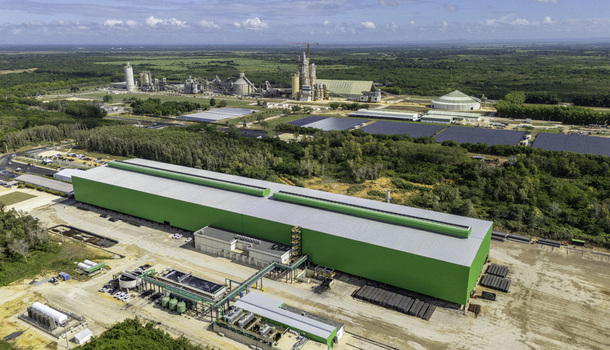 Aerial view of the ECOACERO industrial facility featuring a large green warehouse solar panels and industrial infrastructure in Juan Dolio San Pedro de Macoris Dominican Republic.