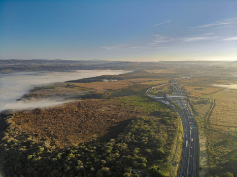 Aerial view of a highway stretching through a landscape with fields and morning fog in Tonala Jalisco Mexico. Aerial view of a highway stretching through a landscape with fields and morning fog in Tonala Jalisco Mexico.