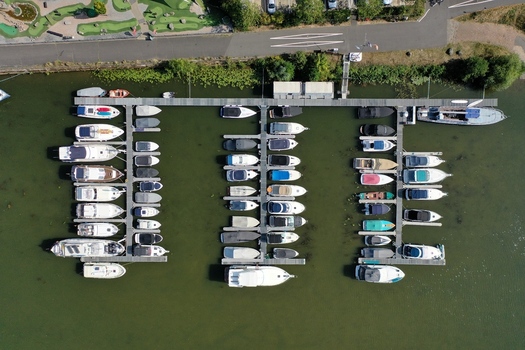 Aerial view of the Aschaffenburger Bootsclub with numerous motorboats and yachts moored at wooden piers on calm green water Aschaffenburg Bayern Germany. Aerial view of the Aschaffenburger Bootsclub with numerous motorboats and yachts moored at wooden piers on calm green water Aschaffenburg Bayern Germany.