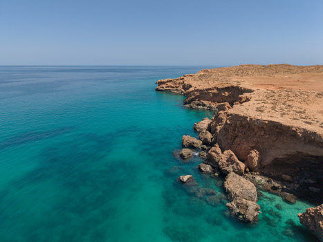 Aerial view of the rugged coastline where the arid land meets the turquoise sea a stunning contrast of colors and textures Siqirah Socotra Yemen. Aerial view of the rugged coastline where the arid land meets the turquoise sea a stunning contrast of colors and textures Siqirah Socotra Yemen.
