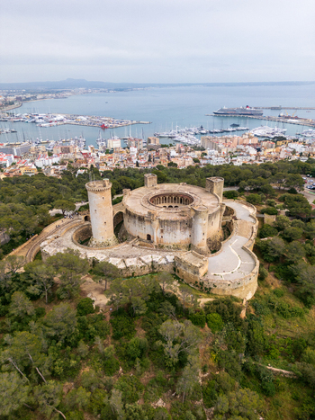 Aerial view of Castillo de Bellver with its unique circular structure and towers overlooking the harbor and city in Palma Illes Balears Spain.