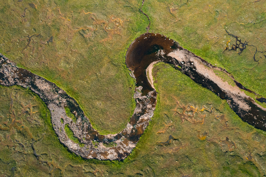 Aerial view of a meandering river winding through the lush green landscape of the Scottish Highlands in Ballachulish Scotland United Kingdom.