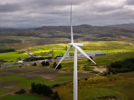 Aerial view of a wind turbine at the Green Mountain SVG Undheim Datasenter construction site surrounded by rolling green hills and fields in Undheim Rogaland Norway. Aerial view of a wind turbine at the Green Mountain SVG Undheim Datasenter construction site surrounded by rolling green hills and fields in Undheim Rogaland Norway.