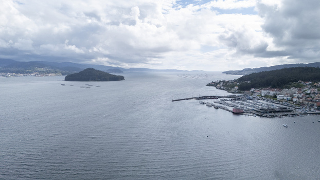 Aerial view of the historic coastal town and marina overlooking the Ria de Pontevedra with Tambo Island under a cloudy sky in Combarro Pontevedra Spain. Aerial view of the historic coastal town and marina overlooking the Ria de Pontevedra with Tambo Island under a cloudy sky in Combarro Pontevedra Spain.
