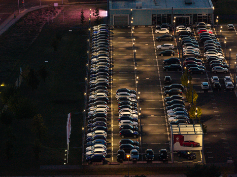 Aerial view of the Audi Zentrum Berlin Adlershof parking lot filled with numerous cars illuminated by streetlights at night in Berlin Berlin Germany. Aerial view of the Audi Zentrum Berlin Adlershof parking lot filled with numerous cars illuminated by streetlights at night in Berlin Berlin Germany.