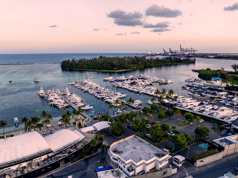 Aerial view of Club Nautico de Santo Domingo Inc. with yachts docked in the marina palm trees and coastal waters at sunset in Andres Santo Domingo Dominican Republic. Aerial view of Club Nautico de Santo Domingo Inc. with yachts docked in the marina palm trees and coastal waters at sunset in Andres Santo Domingo Dominican Republic.