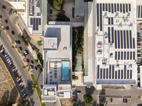 Aerial view of a modern building featuring extensive rooftop solar panels a swimming pool and an adjacent parking lot in the city of Chihuahua Chihuahua Mexico. Aerial view of a modern building featuring extensive rooftop solar panels a swimming pool and an adjacent parking lot in the city of Chihuahua Chihuahua Mexico.