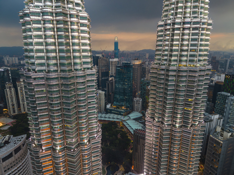 Kuala Lumpur Malaysia 11 March 2026 Aerial view of the Petronas Twin Towers with the city skyline and The Exchange 106 tower under a dramatic sunset sky.