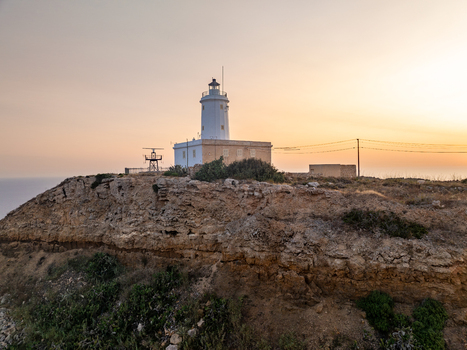 Aerial view of the Ta Gurdan Lighthouse stands majestically against the soft glow of the setting sun a beacon of hope amidst the rugged coastline Ta Gurdan Gozo Malta. Aerial view of the Ta Gurdan Lighthouse stands majestically against the soft glow of the setting sun a beacon of hope amidst the rugged coastline Ta Gurdan Gozo Malta.