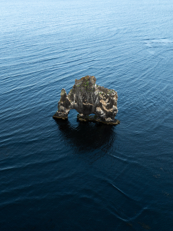 Aerial view of Hv&iacute;tserkur rock formation standing tall in the deep blue waters of the bay Hvitserkur Iceland.