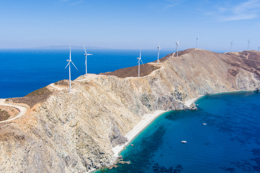 Greece 21 September 2026 Aerial view of wind turbines situated on a rugged coastal ridge overlooking the deep blue Aegean Sea in Greece. Greece 21 September 2026 Aerial view of wind turbines situated on a rugged coastal ridge overlooking the deep blue Aegean Sea in Greece.