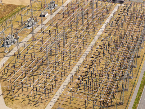 Aerial view of the Amprion Umspannwerk electrical substation featuring complex metal structures power lines and transformers in Pfungstadt Hessen Germany.